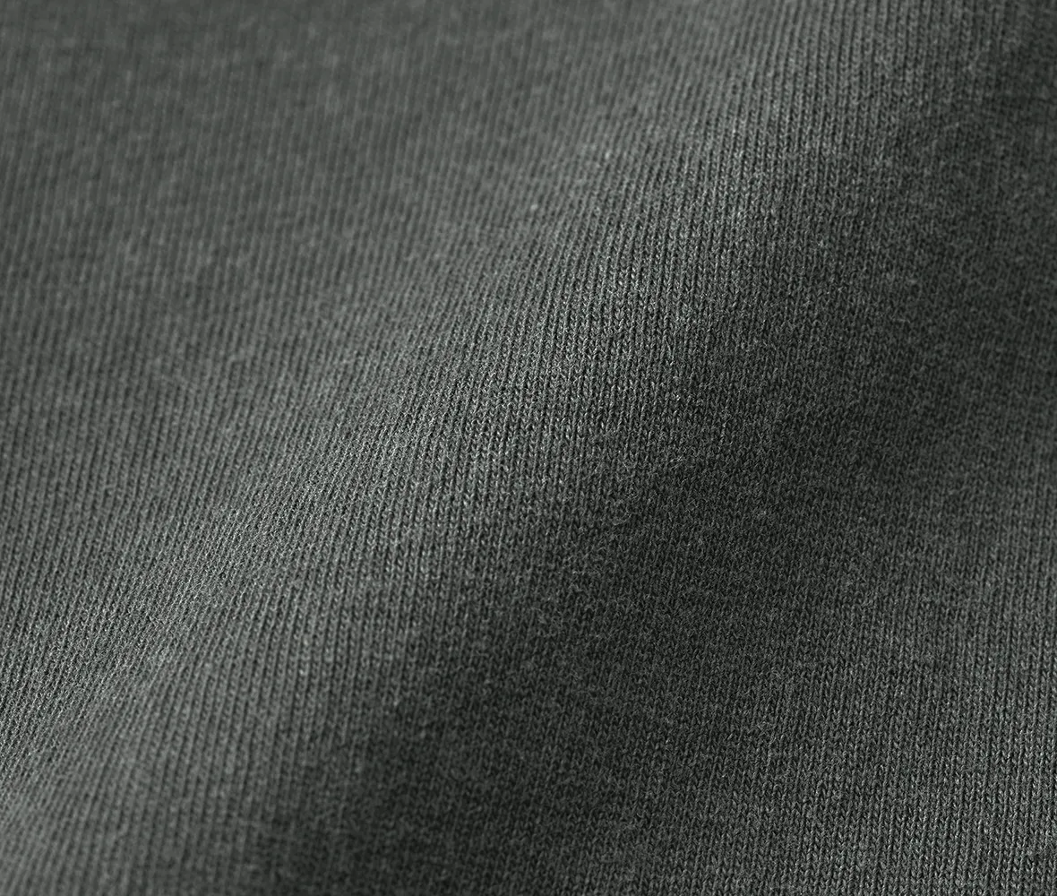 製品ボールバイオウォッシュによるダメージ加工で、古着のようなフェード感と風合いを実現